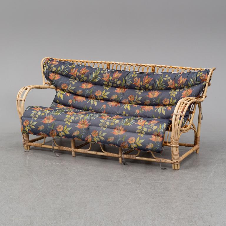 A rattan and glass table and a rattan sofa, second half of the 20th century.