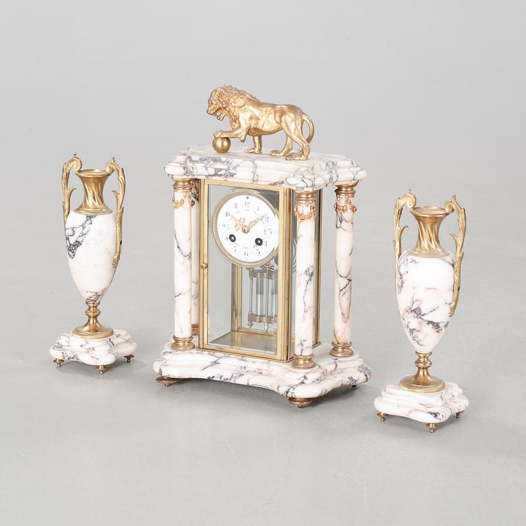 A Louis XVI style table clock and two urns, around the year 1900.