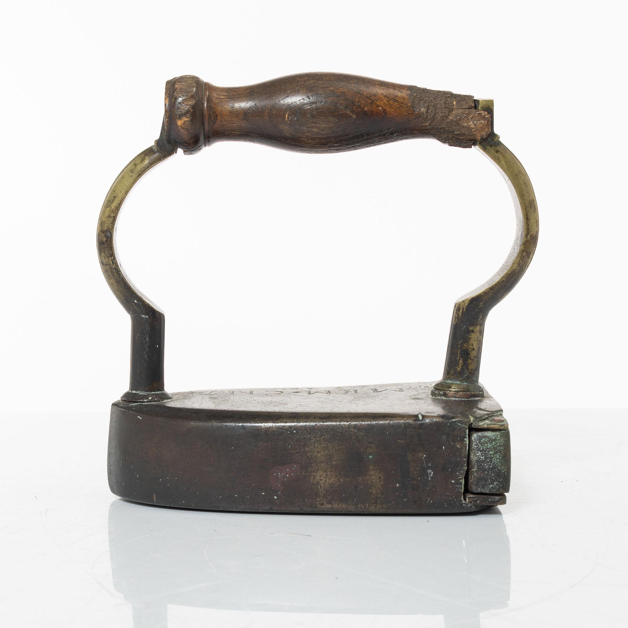 A brass clothes iron, dated 1710.