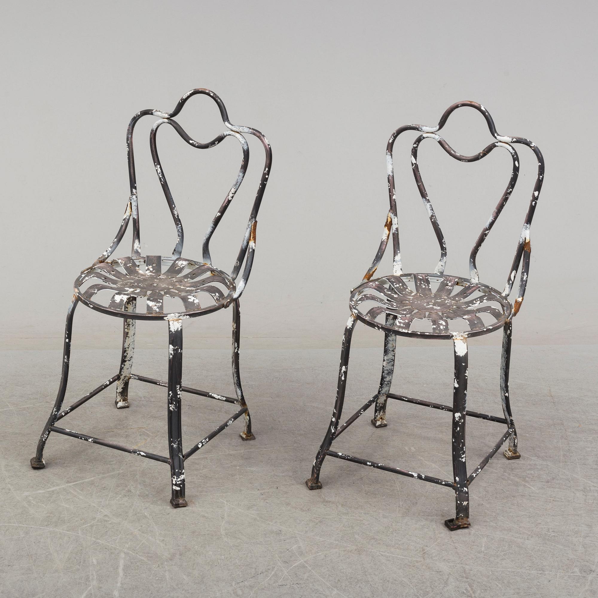a pair of modern iron graden chairs,