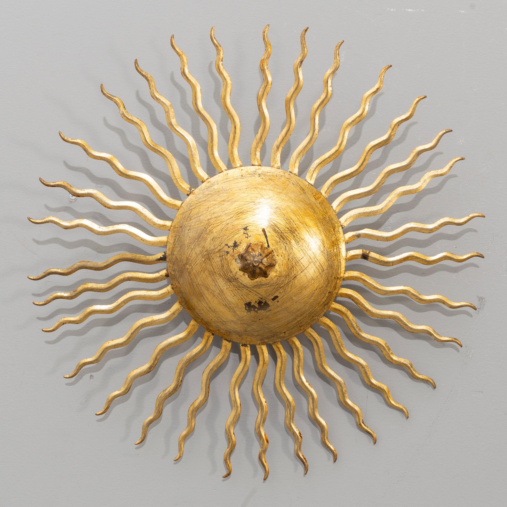 A ceiling lamp in the shape of the sun. Mid 20th century.