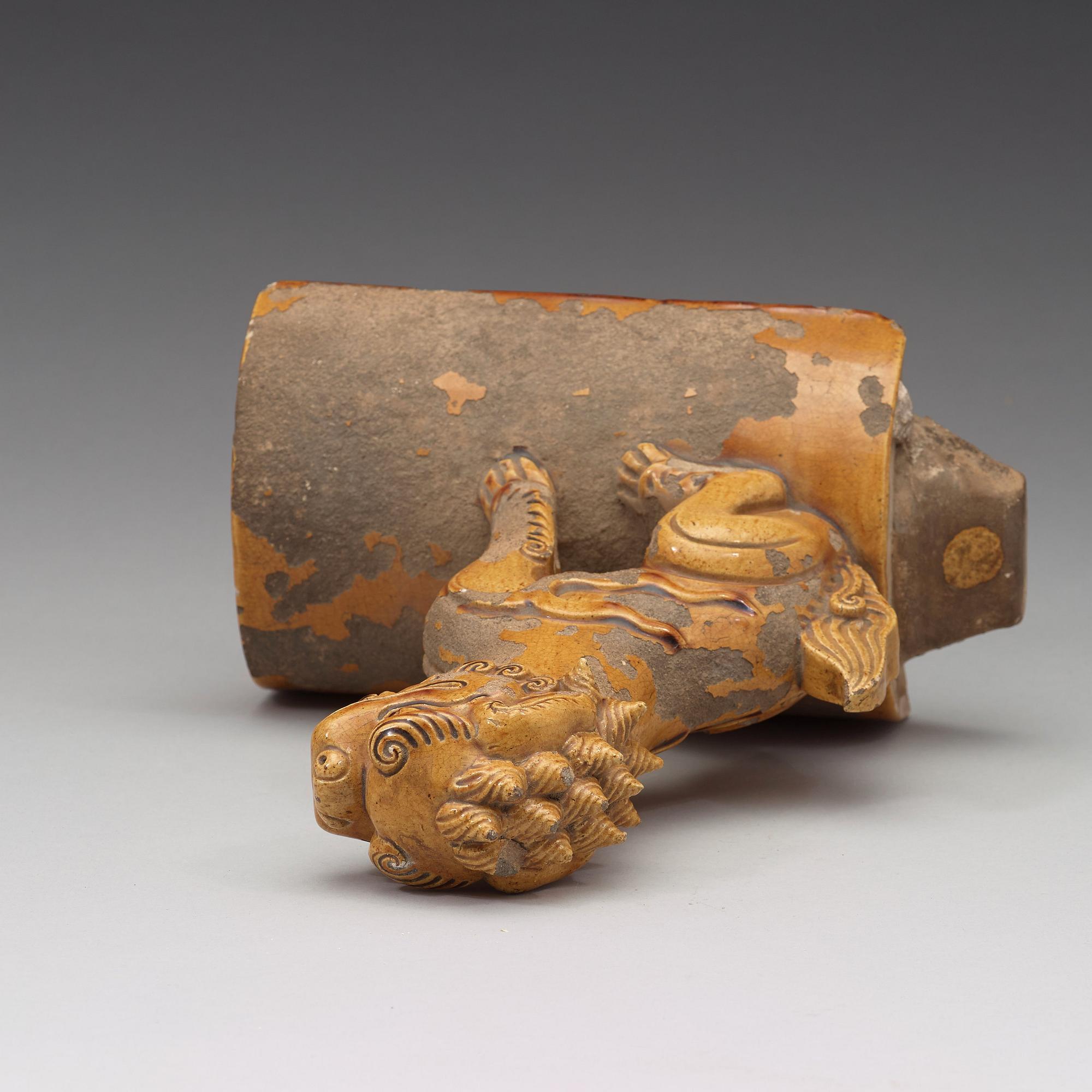 A yellow glazed roof tile figure of a Buddhist lion, Ming dynasty (1368-1644).