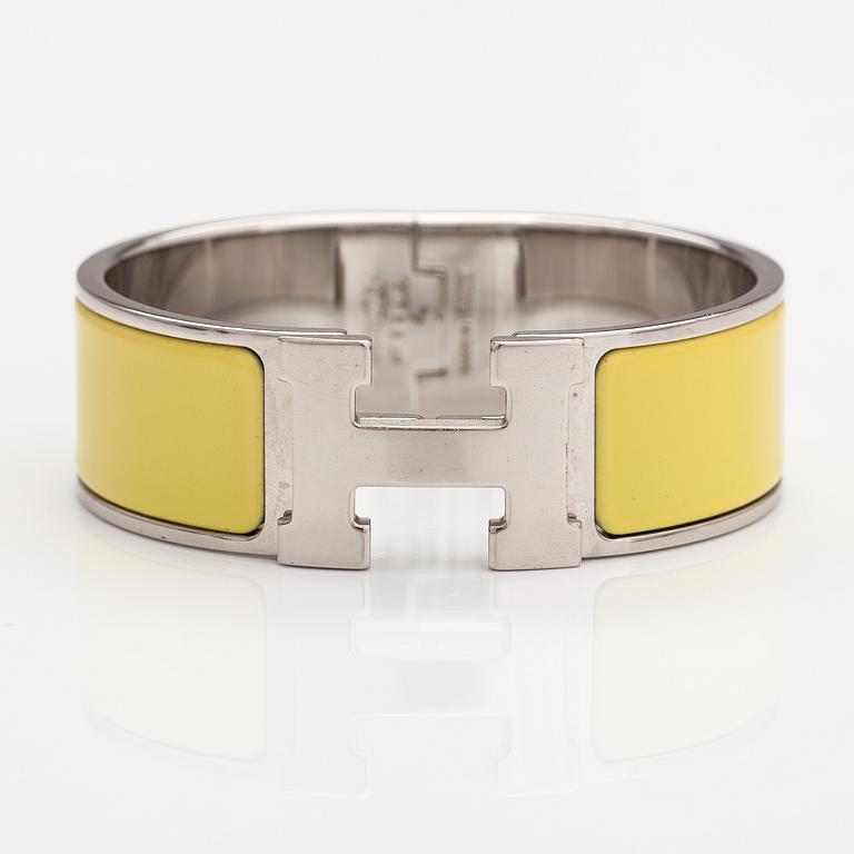 Hermès, A "Click H" bracelet made of metal and yellow enamel. Marked Hermès, ST1105, S, Made in France.