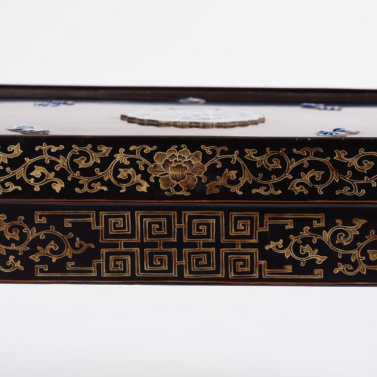 A Chinese black lacquered table with porcelain placques, presumably first half of the 20th century.