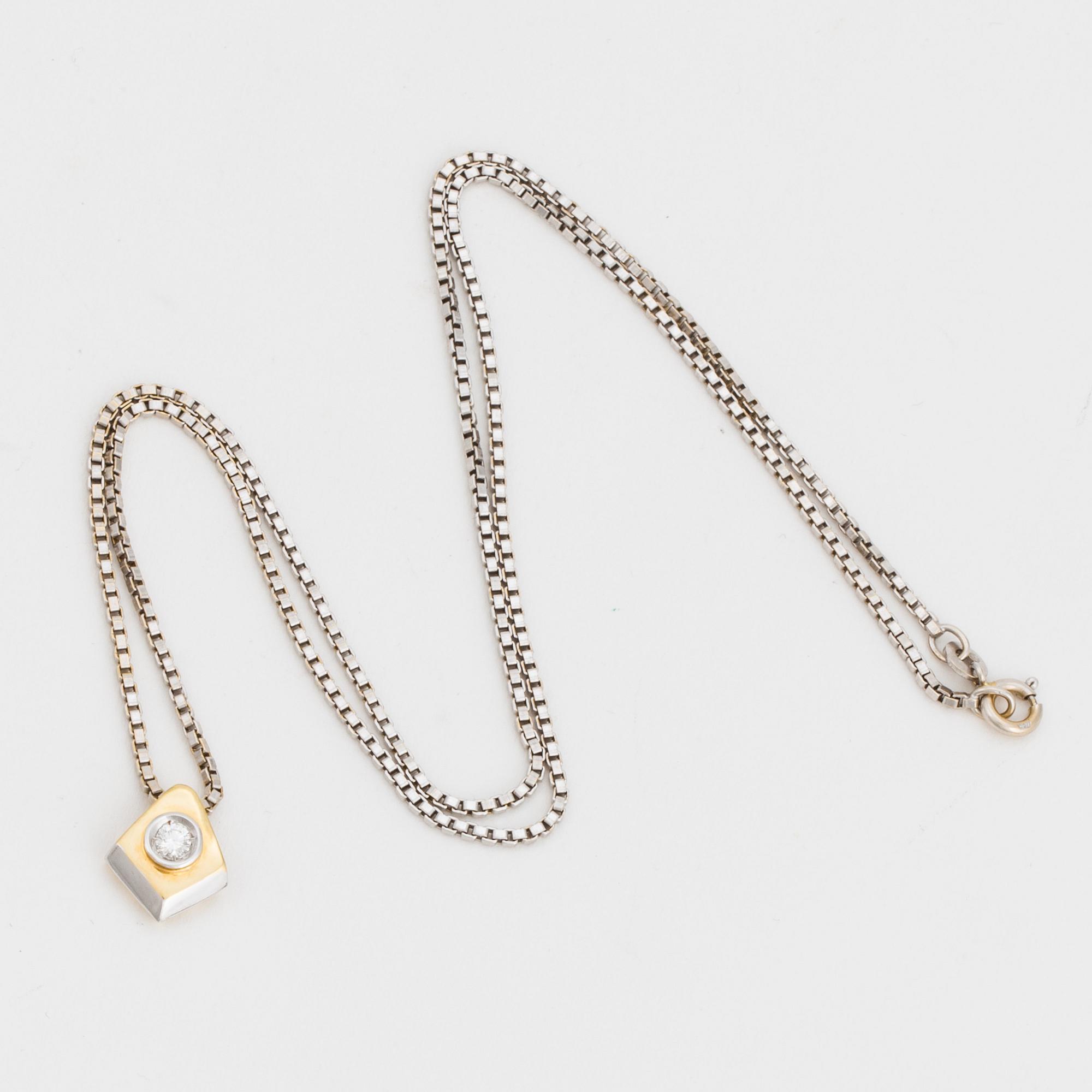 A chain and a pendant set with a round, brilliant-cut diamond.