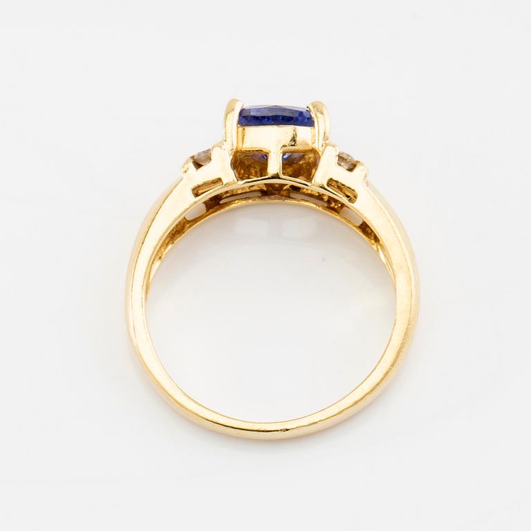 Ring in 18K gold set with a faceted tanzanite and round brilliant-cut diamonds.