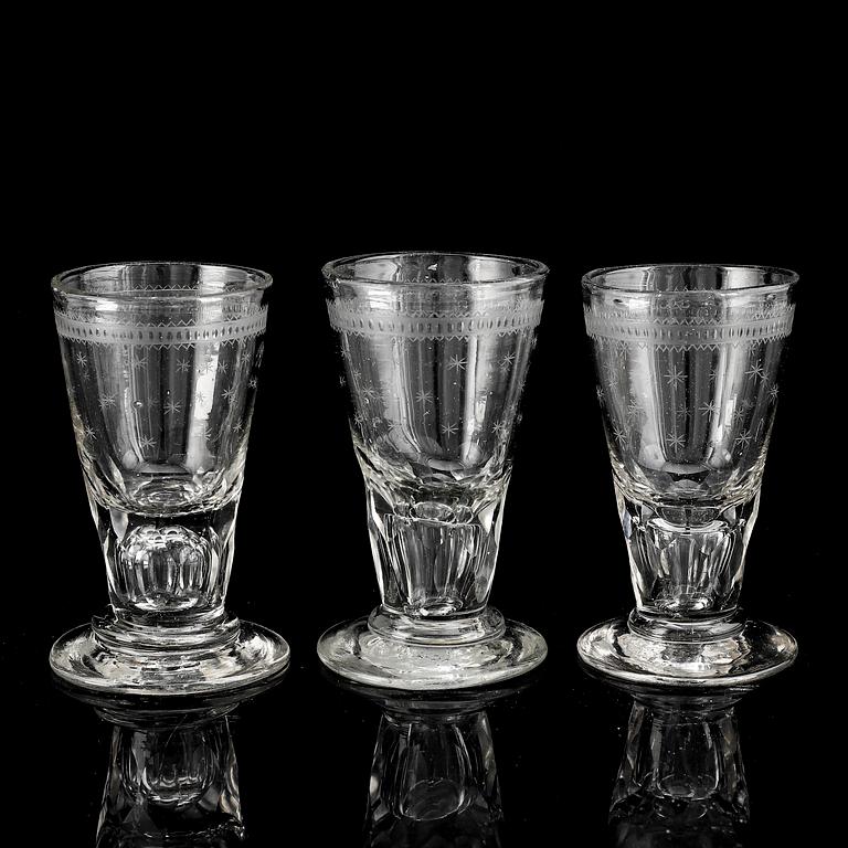 A glass bottle and three vodka glasses, 19th Century.