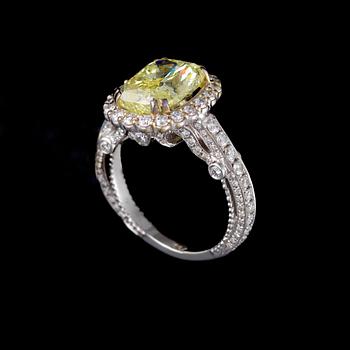 RING, 18K vitguld, diamant 5,014 ct, briljantslipade  diamanter totalt ca 0,90 ct. Vikt ca 8 g.