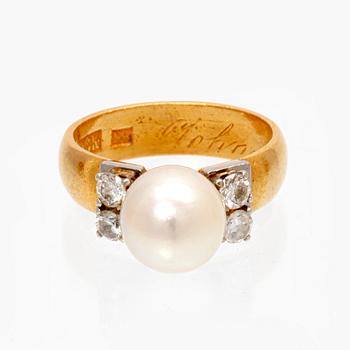 A 23K white and red gold ring with round brilliant cut diamonds and a cultured pearl.