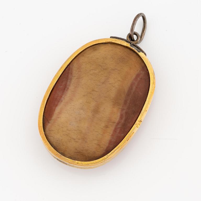 An 18K gold pendant with a hardstone cameo.