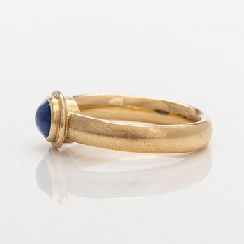 An 18K gold ring with a cabochon-cut sapphire.