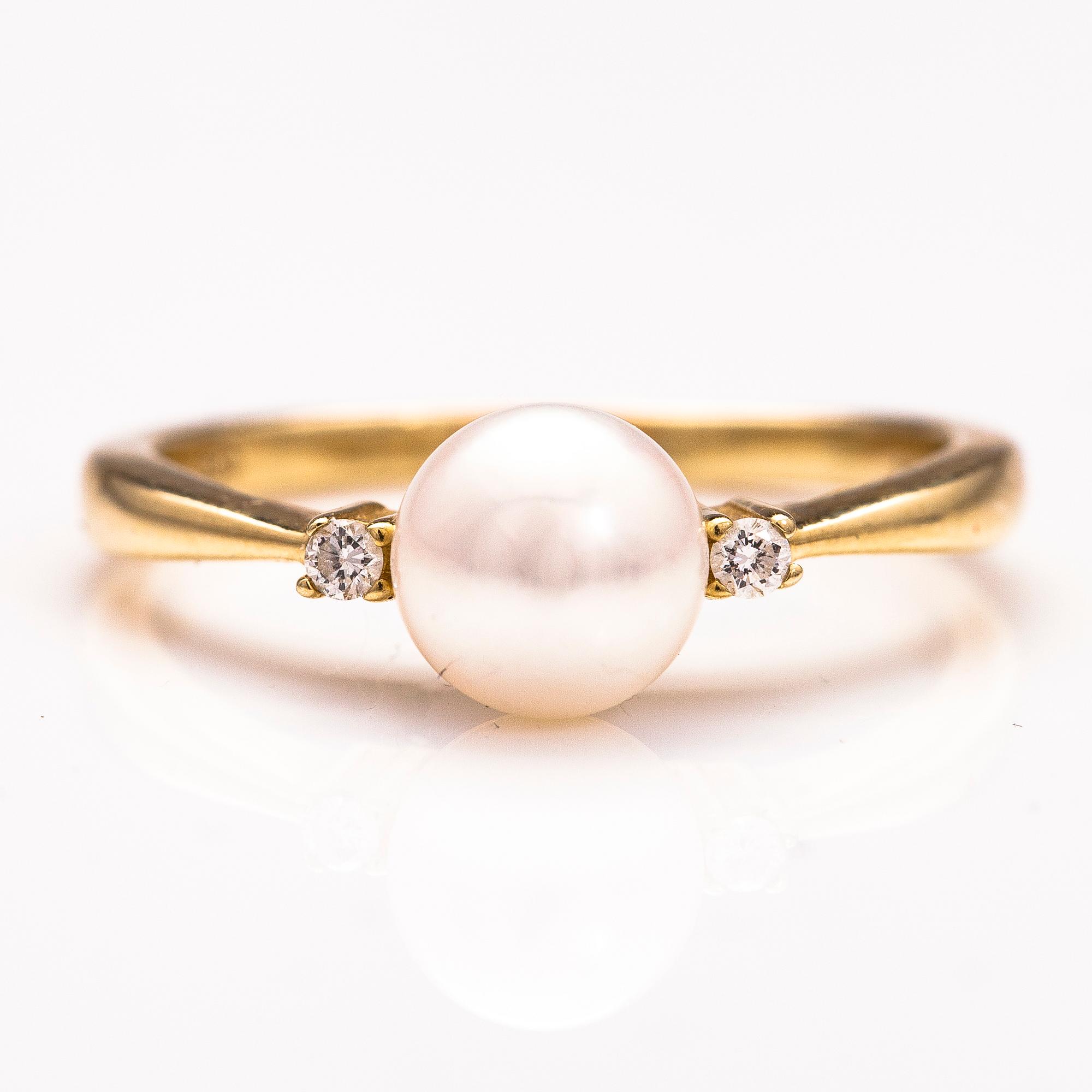 A 14K gold ring wirh diamonds ca 0.10 ct in total and a cultured pearl.