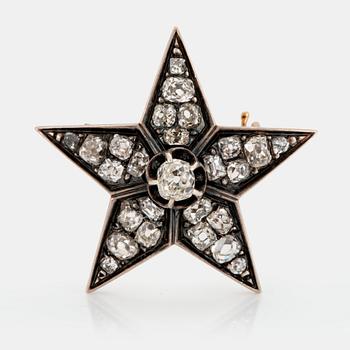 1059. A 14K gold and silver star brooch set with old-cut diamonds.