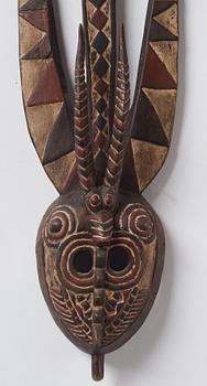 A sculptue and two masks reportedly from The Ivory coast, from the second half of the 20:th century.