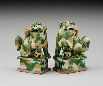 A pair of green and yellow glazed bisquit cencers, in the shape of sitting Buddhist lions, Qing Dynasty, Kangxi (1662-1722).