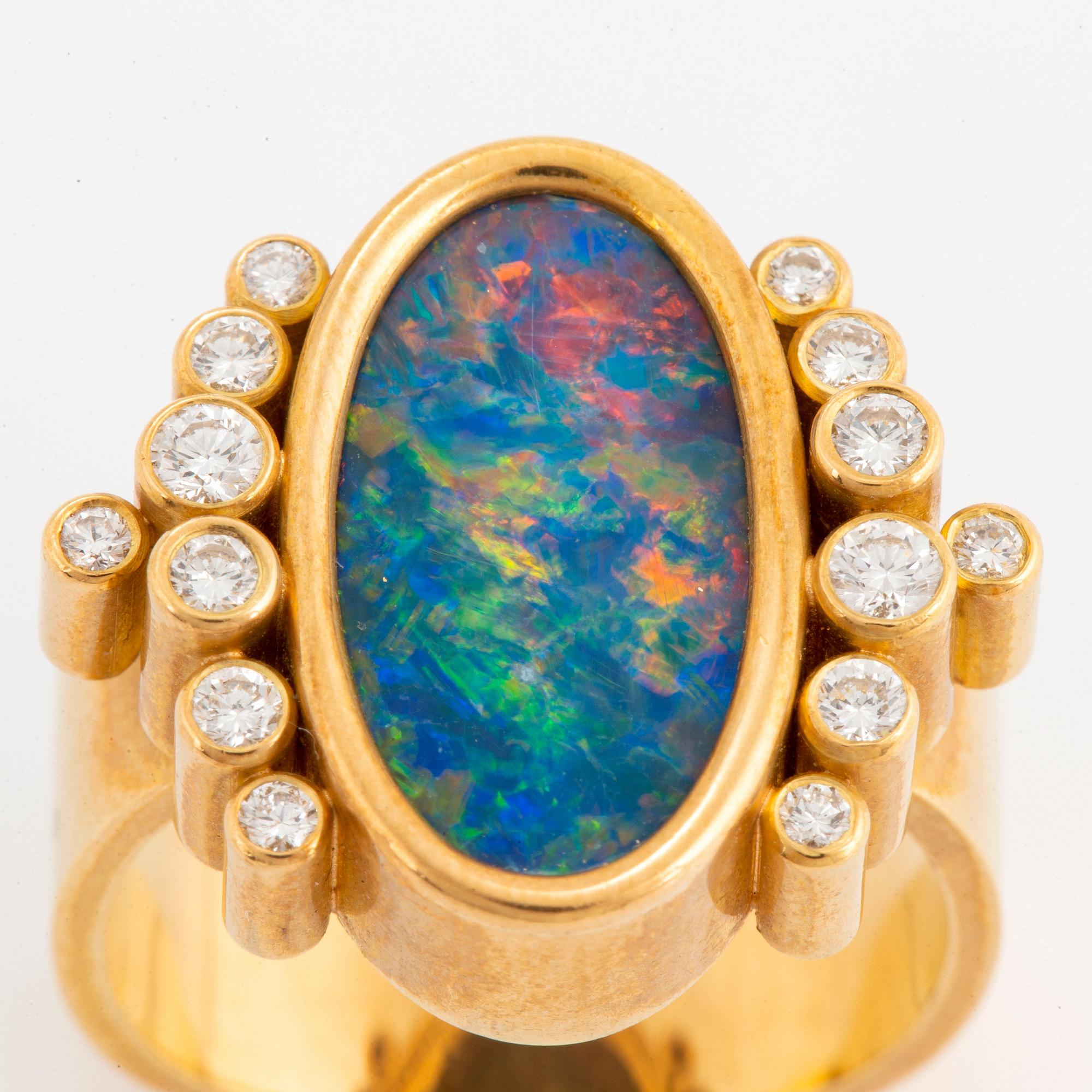 An 18K gold and opal ring set with round brilliant-cut diamonds.