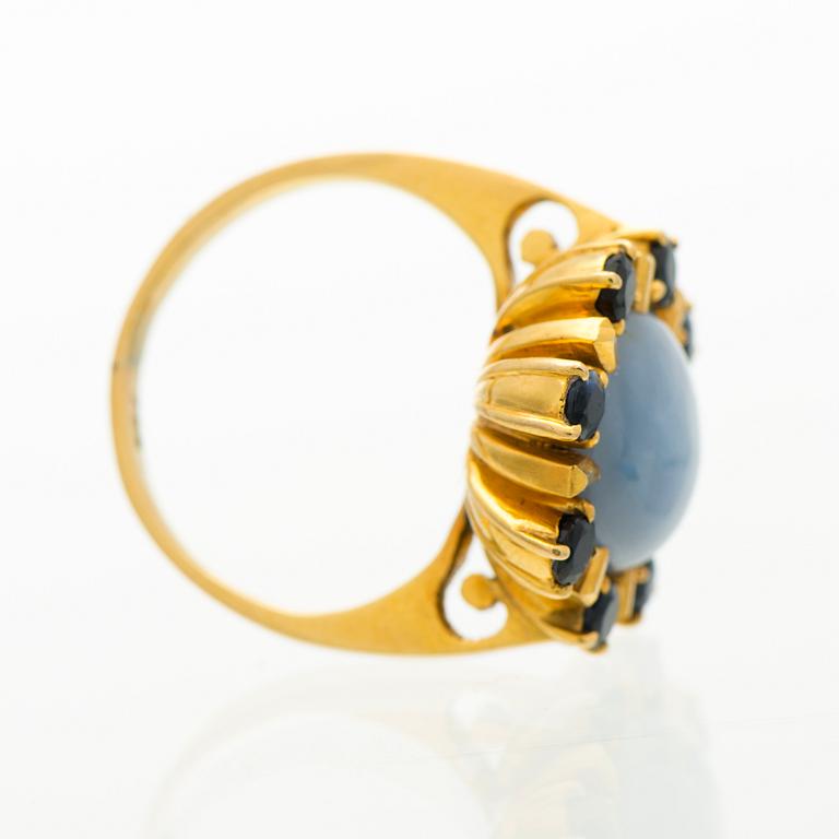 A RING, cabochon cut star sapphire, facetted sapphires, 18K gold.