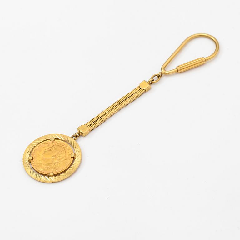A keychain made of 18K gold with a 900 gold Helvetia 20 franc coin.