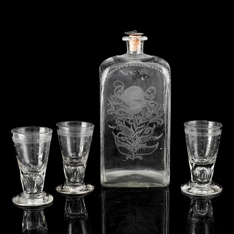 A glass bottle and three vodka glasses, 19th Century.