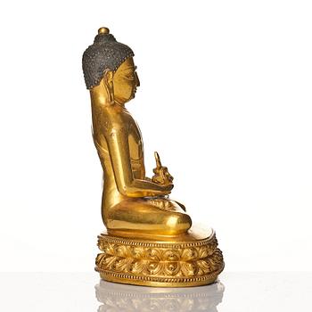 A gilt copper alloy figure of buddha, Tibeto Nepalese, stylistically from the 14th/15th Century,