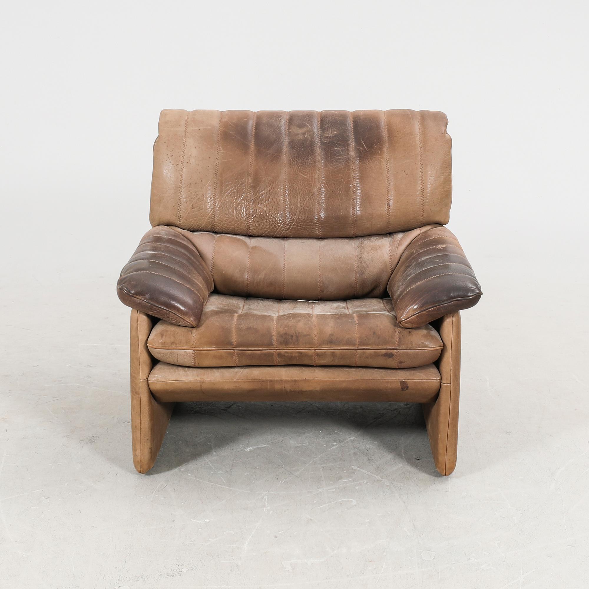 A set of two leather armchairs and a stool by De Sede, Schweiz second half of the 20th century.
