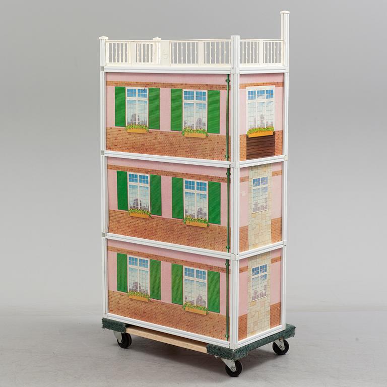 A plastic doll's house with six dolls, furniture and clothes, 20th century.