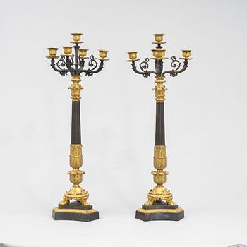 A pair of French Empire-style patinated and gilt bronze five-light candelabra, later part 19th century.