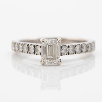 18K white gold ring set with an emerald-cut diamond and round brilliant-cut diamonds.