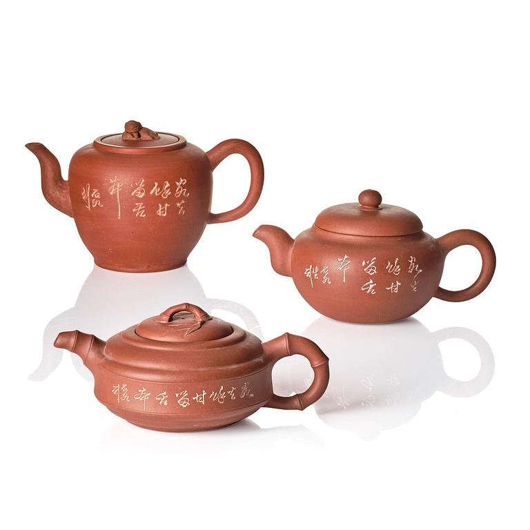 A group of three Chinese yixing tea pots with cover.