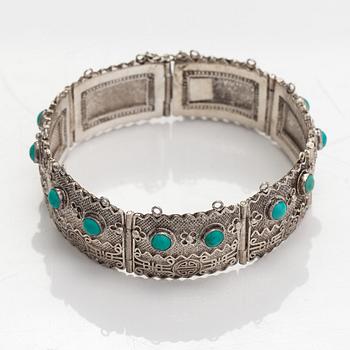 A silver bracelet and ring with turquoises. China.