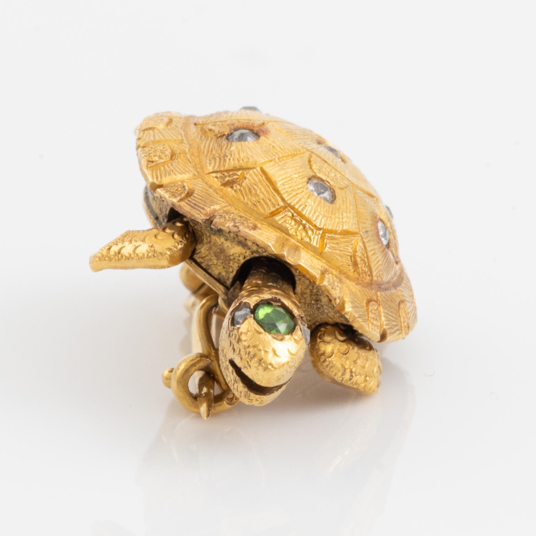 A brooch in the shape of a turtle.