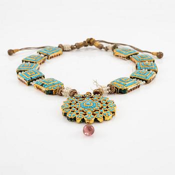 An antique gold and enamel Qajar necklace with pearls set with turquoises and with a garnet drop.