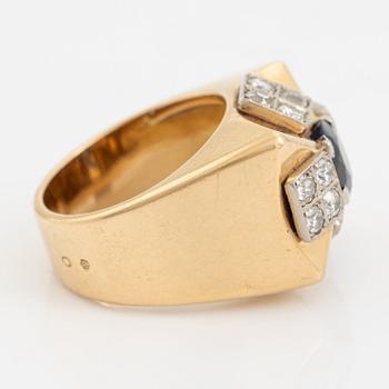 An 18K gold ring set with a faceted sapphire and diamonds.