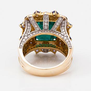 A 14k gold ring with an emerald ca. 6.39 ct, tanzanites and diamonds ca. 1.25 ct in total.