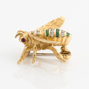 Brooch 18K gold set with round faceted emeralds and rubies, as well as round brilliant-cut diamonds.