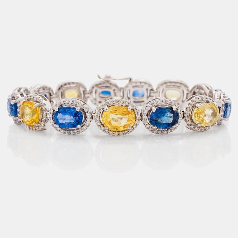 A yellow and blue sapphire and brilliant cut diamond bracelet. Total carat weight of sapphires circa 28.00 cts.