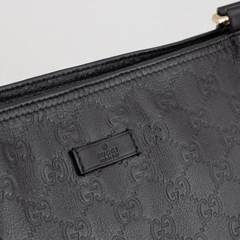 Gucci, a leather messenger bag.