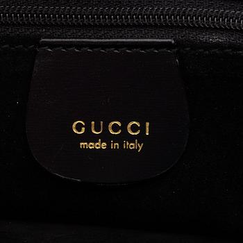 Gucci, a black suede handbag.