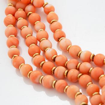 A four strand coral necklace with an 18K gold clasp set with coral and round brilliant-cut diamonds.