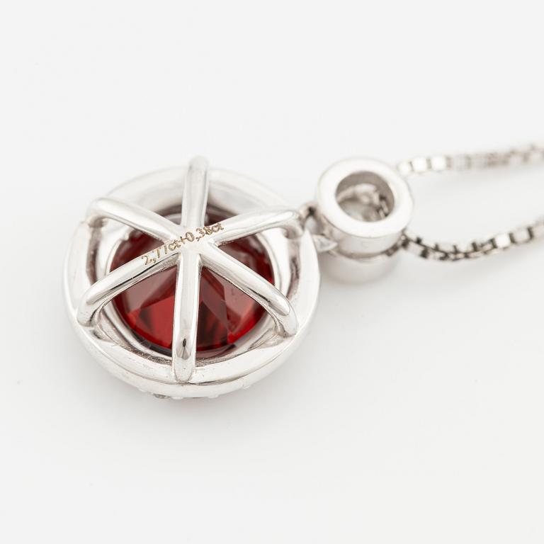 Pendant with a chain in 18K gold set with a faceted garnet and round brilliant-cut diamonds.