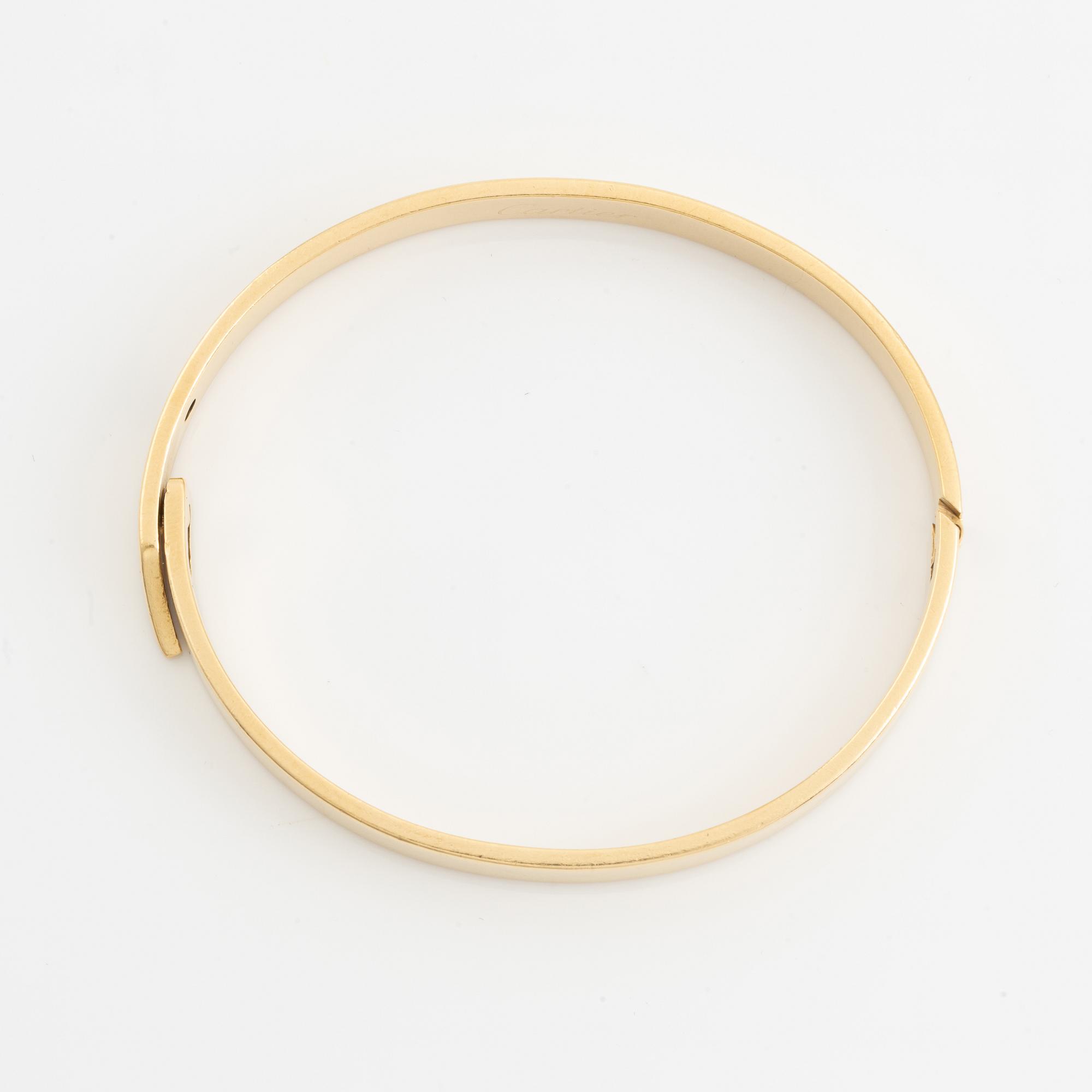 A Cartier "Anniversary Bracelet" in 18K gold set with a round brilliant-cut diamond.