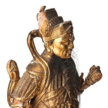 A gilt and lacquered standing figure of a guardsman, Qing dynasty.