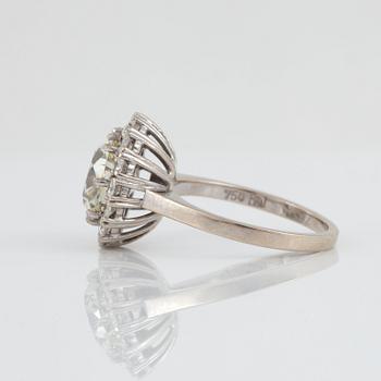 A cushion-cut diamond, circa 3.07 ct ring. The center diamond is surrounded by pavé set brilliant-cut diamonds.