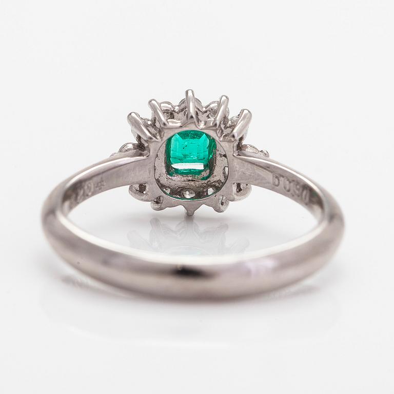 A platinum ring, with an emerald and brilliant- and marquise-cut diamonds.