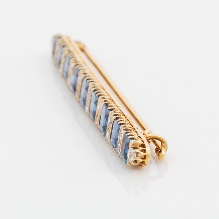 An 18K gold brooch set with step-cut sapphires and old-cut diamonds.