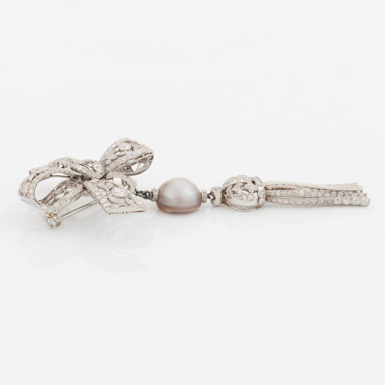 A platinum bow brooch set with old-cut diamonds with a detachable pearl and platinum pendant.