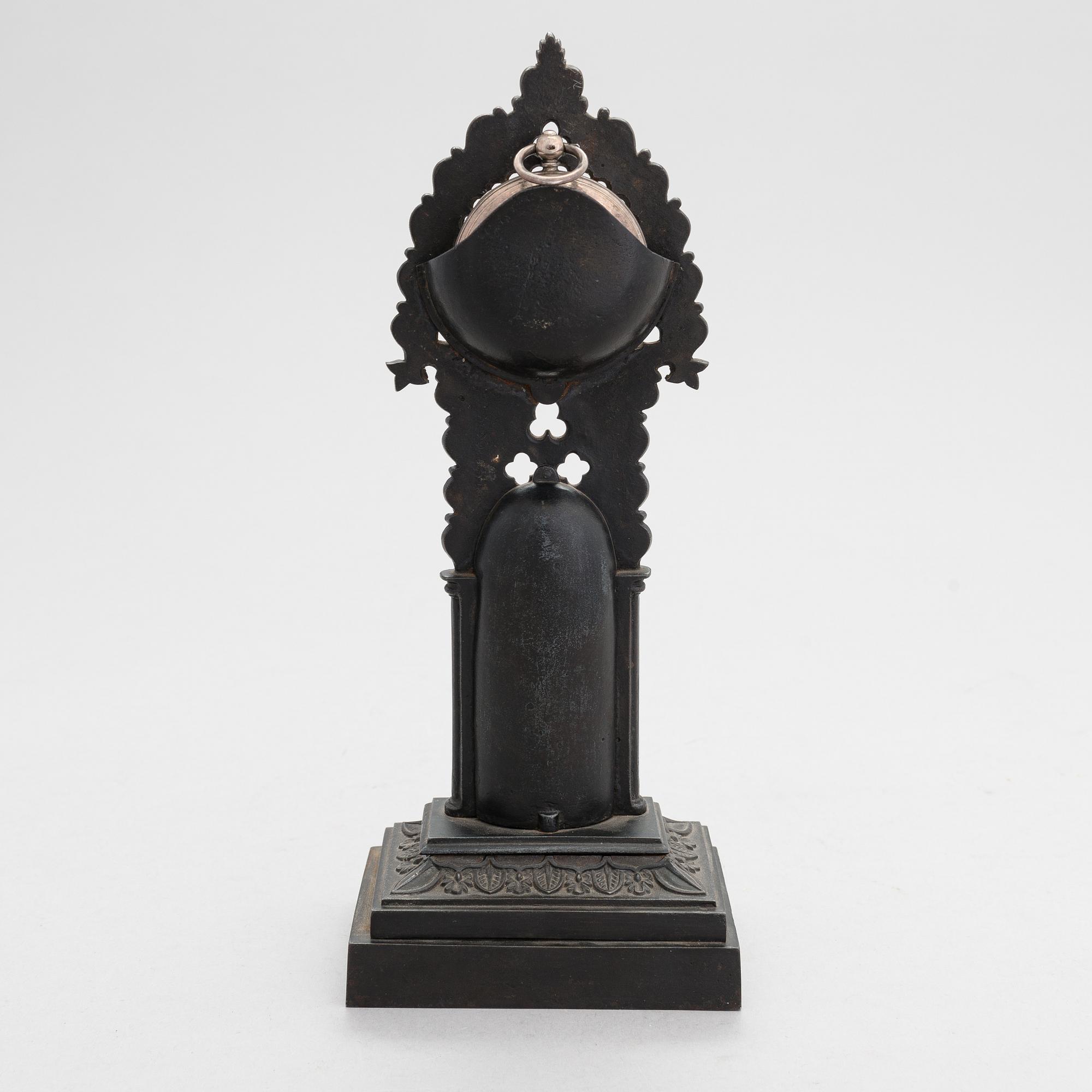 A neo-gothic cast iron pocket watch stand with a pocket watch. 19th century.