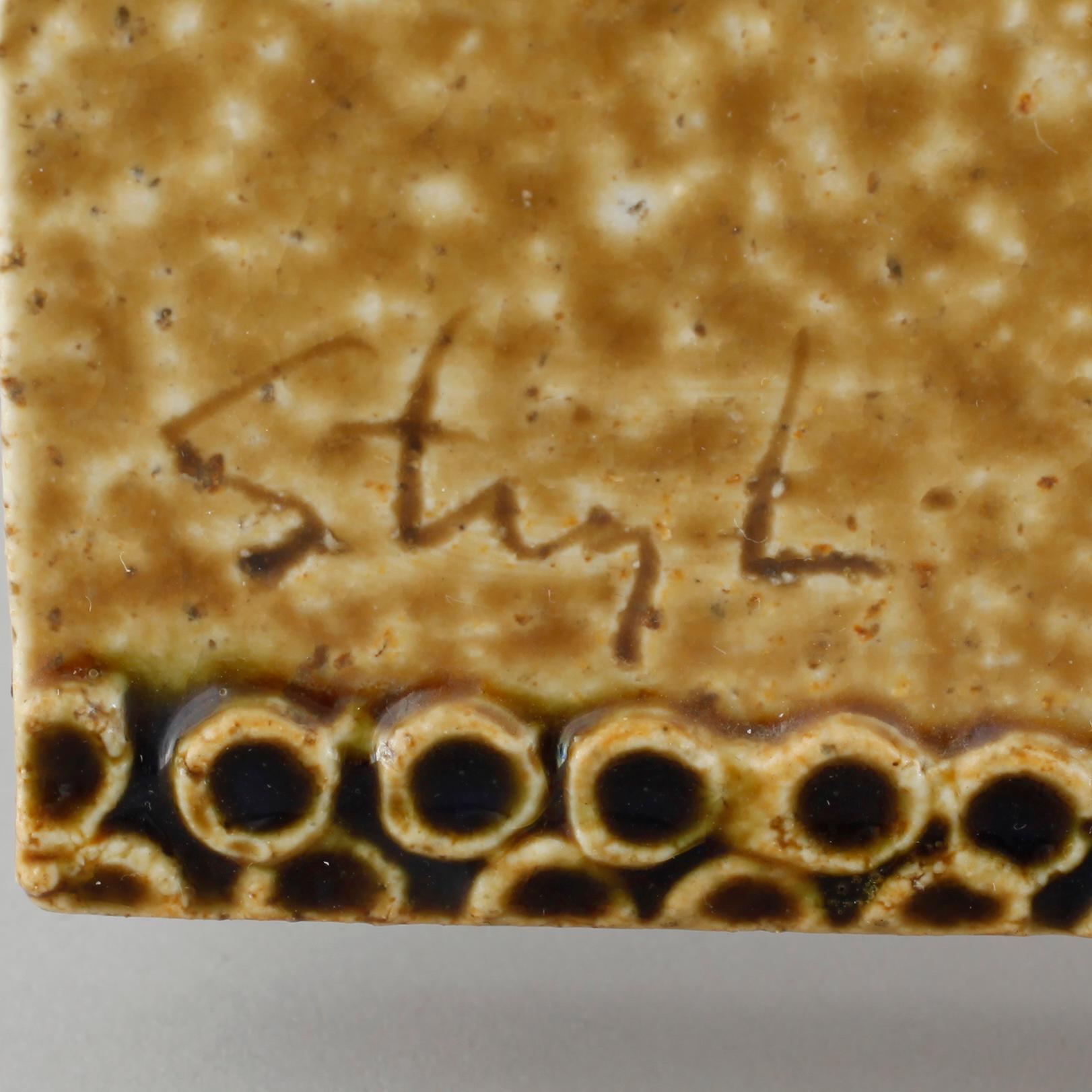 A stoneware wall plaque by Stig Lindberg, signed in the ceramics.