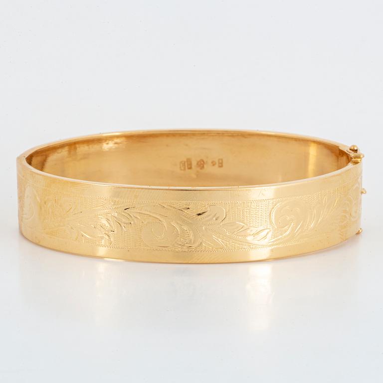 An 18K gold bangle.
