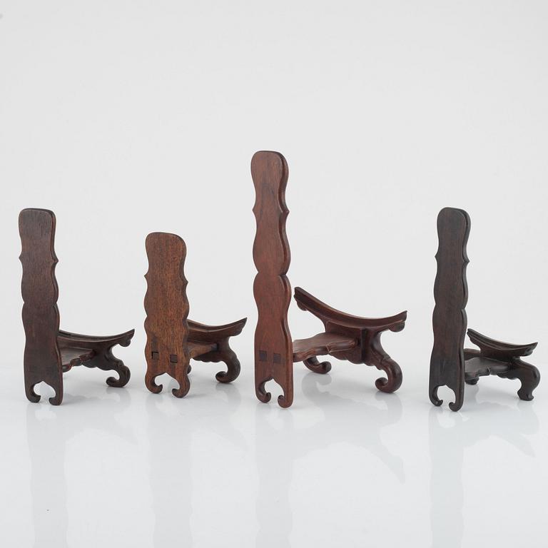 Seven hardwood stand for plates and vase, and one lid, China, 20th century.